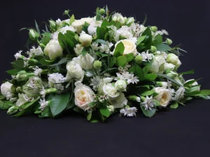 Rouwstuk White Tears. Een groot bloemstuk met verschillende witte bloemen, afgewerkt met groen. Gemaakt door Bloeibloemen.nl