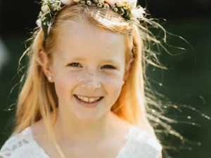 Bohemian haarkrans, een bruidsmeisje met een witte jurk aan en een bloemenhaarband in haar haar