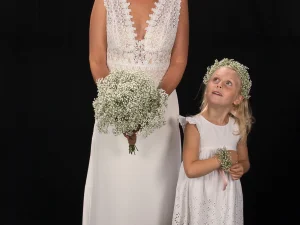 Gypsie love, Een bruid en een bruidsmeisje, de bruid heeft een bruidsboeket in haar hand met witte bloemen en het bruidsmeisje heeft een haarkrans en bloemenarmband om, gemaakt door Bloeibloemen.nl