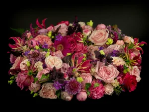Rouwkrans Lovely met bloemen voor een begrafenis in de kleuren roze, rood, paars en geel.