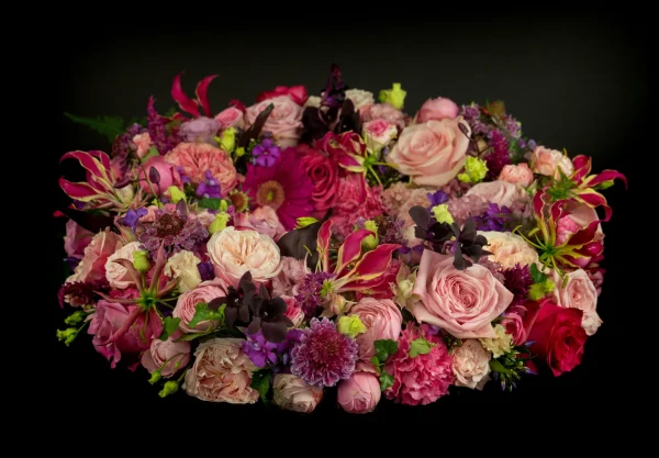 Rouwkrans Lovely met bloemen voor een begrafenis in de kleuren roze, rood, paars en geel.